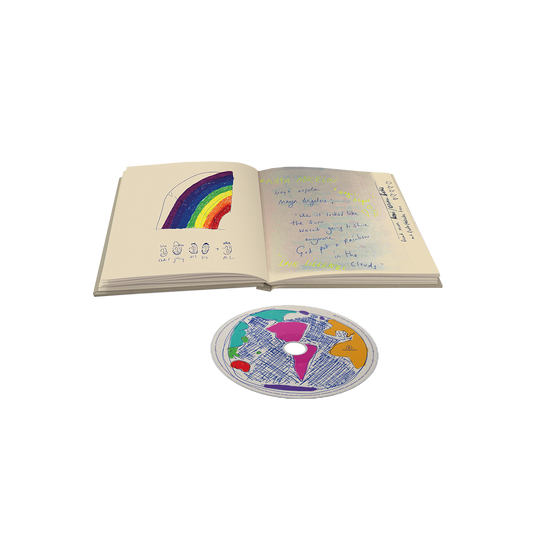 Moon Music CD&2notebook pages, with playful cartoon faces of Chris, Will, Jonny, Guy and Phil underneath the drawing of a🌈on a cream-colored page. Jonny wears a cap. We can read the words when it looked like the sun would not shine anymore, God put a rainbow in the clouds; and Maya Angelou several times. Other words are hard to decipher. On the disc itself, the center label is a hand-drawn globe in fuchsia, orange, teal, and red.
